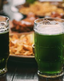 Green beers and St. Patrick's Day appetizer on table.