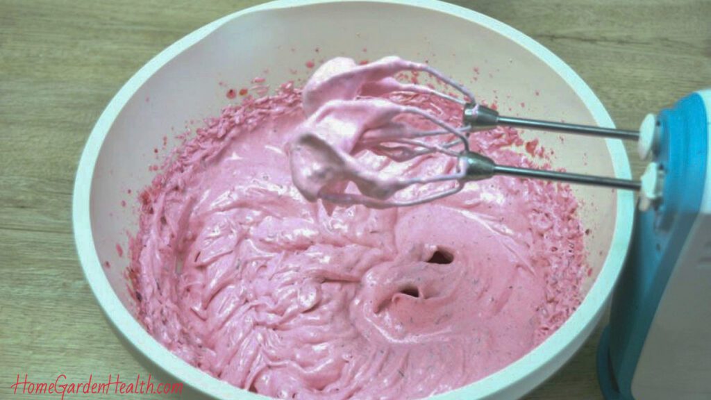 Mixing bowl with raspberry buttercream frosting ingredients
